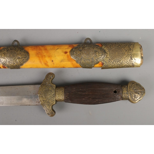 444 - A Chinese Jian short sword featuring ribbed grip, brass pommel and brass mounts on tortoiseshell sca... 