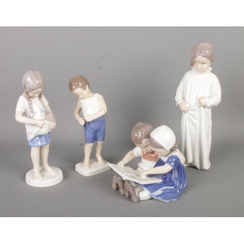 450 - Four Bing and Grondahl ceramic figure groups; Boy 1759, Girl with Kitten 1779, Children Reading 1567... 