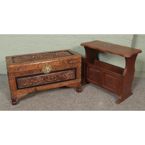 459 - A heavily carved camphor wood oriental chest together with an oak magazine rack.