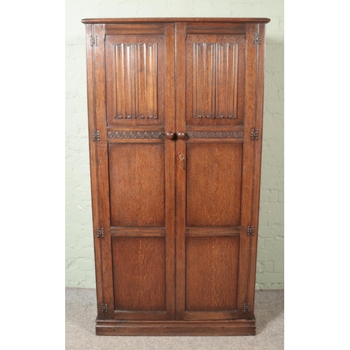 462 - A Crown Ay Furniture carved oak double wardrobe with linen fold decoration.