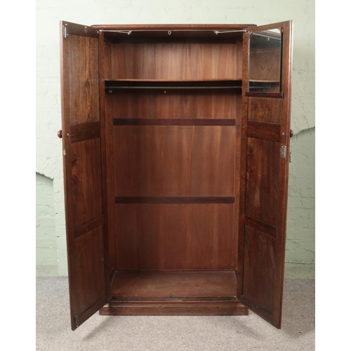 462 - A Crown Ay Furniture carved oak double wardrobe with linen fold decoration.