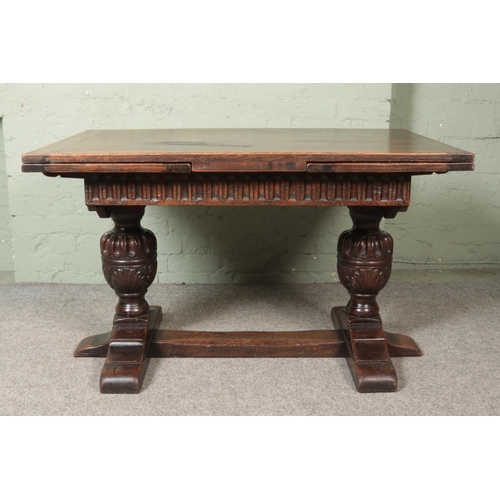 463 - An oak drawer leaf refectory style table. With carved bulbous pineapple supports.