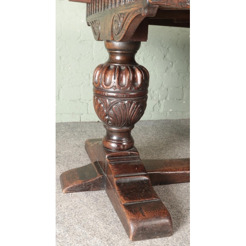 463 - An oak drawer leaf refectory style table. With carved bulbous pineapple supports.