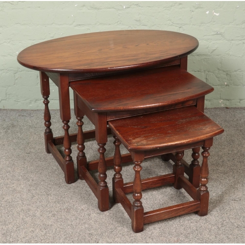 473 - An Old Charm oak nest of three occasional tables with turned supports.