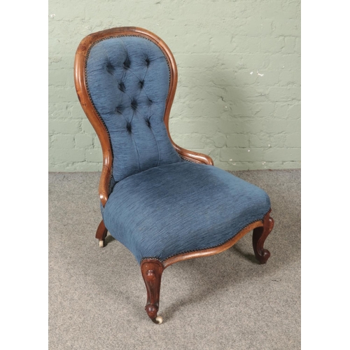 478 - A Victorian blue upholstered button back nursing chair raised on castors.