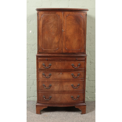 481 - A bow fronted mahogany drinks cabinet, with cupboard doors and brushing slide over four drawers.

Hx... 