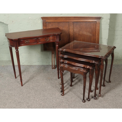 493 - A nest of four mahogany tables together with a mahogany console table and single bed headrest