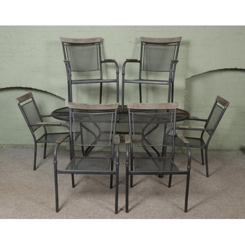 508 - A metal garden table, with six matching chairs, featuring wooden top back and arm rests.