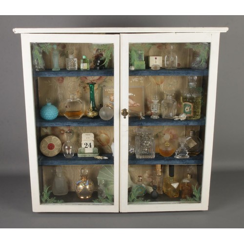 158 - A white painted glazed cabinet housing a large quantity of scent bottles, including vintage examples... 