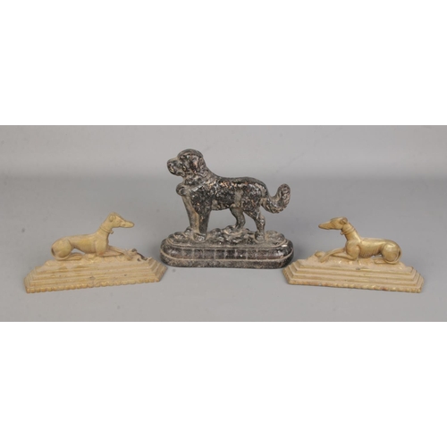 12 - Three metal dog door stops to include cast iron St. Bernard and two brass Greyhound examples.