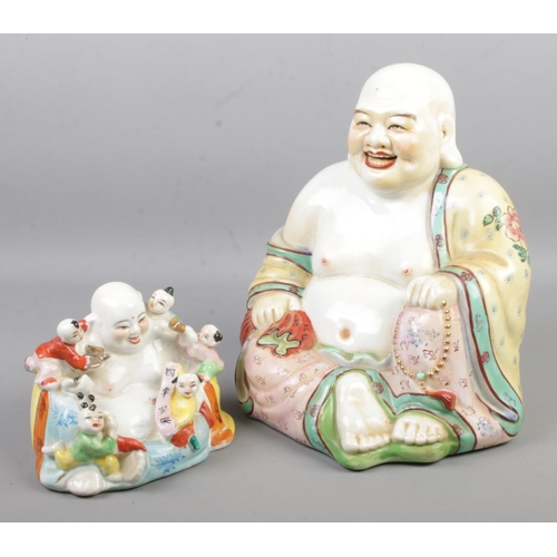 126 - Two Famille Rose laughing buddhas, the smaller example with children.