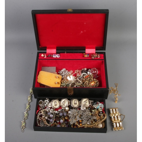 133 - A vintage musical jewellery box with contents of assorted costume jewellery to include bracelets, br... 