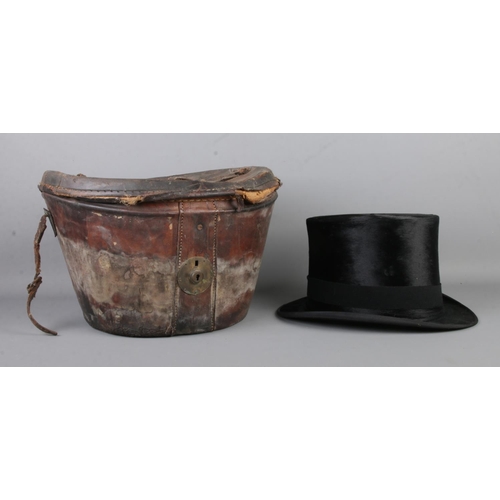 33 - A Woodrow silk top hat, in vintage leather hat box. Front to back 20cm, side to side 15.5cm.