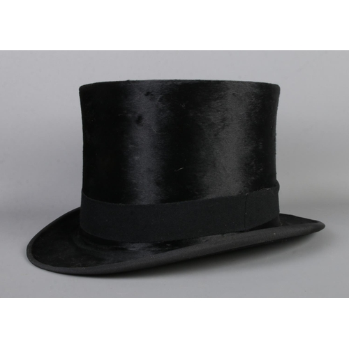 33 - A Woodrow silk top hat, in vintage leather hat box. Front to back 20cm, side to side 15.5cm.