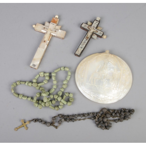 45 - A collection of religious items to include rosary beads, carved mother of pearl shell depicting the ... 