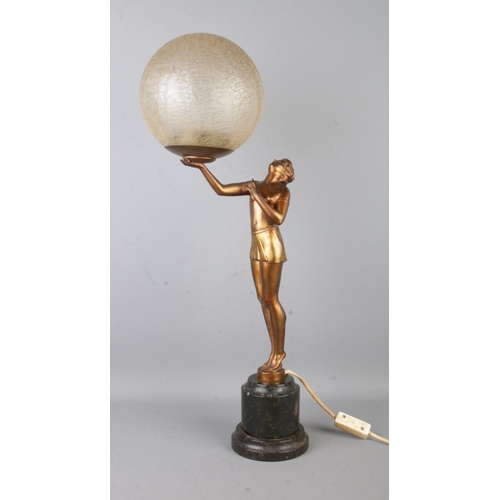 73 - An Art Deco style table lamp, formed as a gilt maiden with outstretched arm, holding up a crackle sh... 