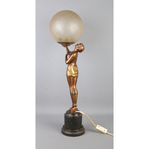 73 - An Art Deco style table lamp, formed as a gilt maiden with outstretched arm, holding up a crackle sh... 