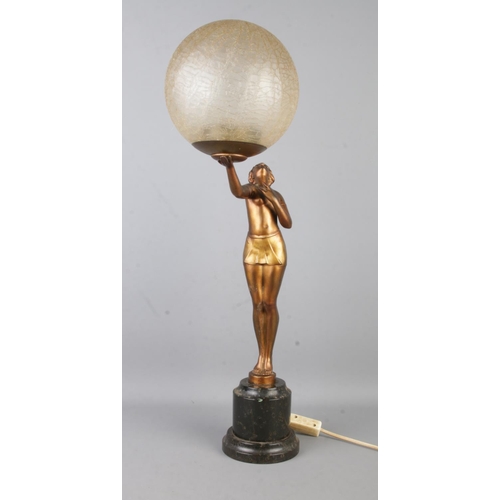 73 - An Art Deco style table lamp, formed as a gilt maiden with outstretched arm, holding up a crackle sh... 