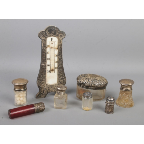 480 - A collection of silver mounted and silver topped items, to include scent bottle, hair tidy, pepperet... 