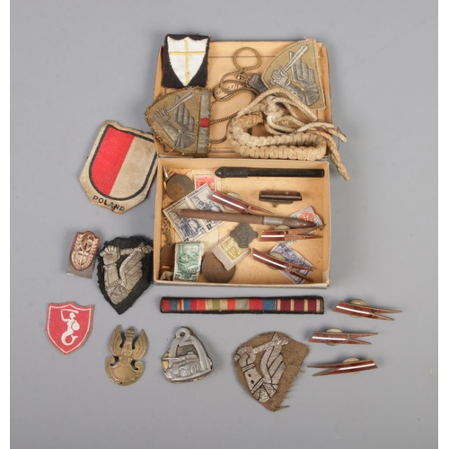 484 - A small collection of WWI/WW2 military collectables to include several Polish examples such as eagle... 