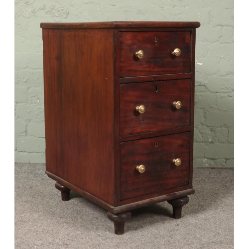 495 - A small mahogany bedside chest of three drawers featuring brass escutcheons and handles. Approx. dim... 