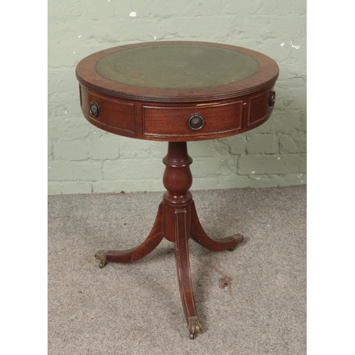 496 - A leather inset circular drum table raised on lion paw feet and castors. Approx. dimensions 51cm x 6... 