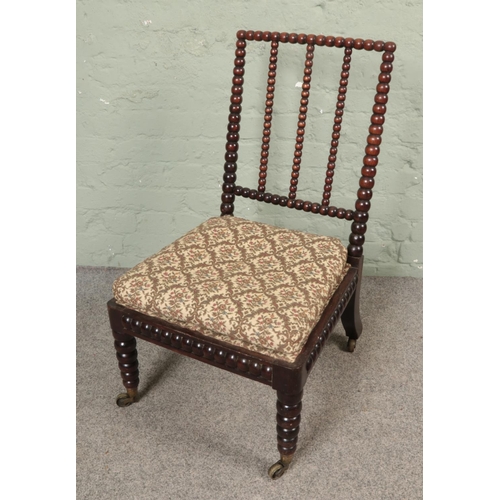 502 - A Victorian bobbin turned nursing chair with upholstered seat