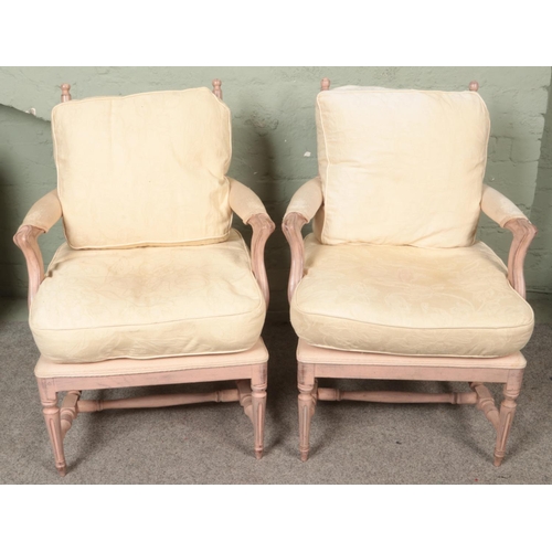 527 - A pair of painted French Louis style elbow armchairs with cushioned seat and back.