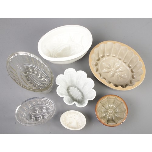 8 - A collection of jelly moulds including glass and stoneware examples.