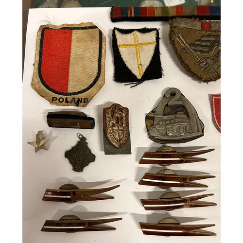 484 - A small collection of WWI/WW2 military collectables to include several Polish examples such as eagle... 