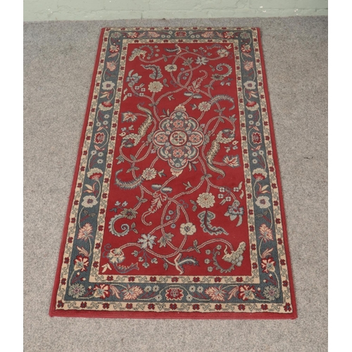 275 - A small red Turkish Ekol acrylic rug in the floral Sarmask design. Approx. size 80cm x 150cm.