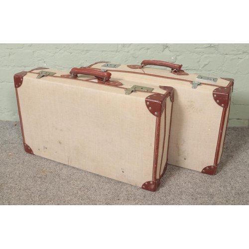 291 - Two vintage canvas and leather bound suitcases, both being stamped to inside Navy possibly military ... 