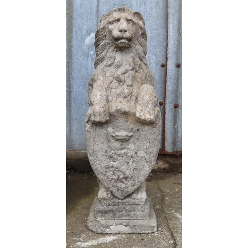 309 - A reconstituted stone statue of a lion rearing over a heraldic shield