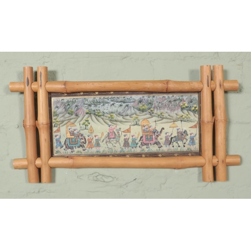 335 - A bamboo framed silk painting depicting Oriental travellers in convoy. Height: 14cm, Width: 27cm.