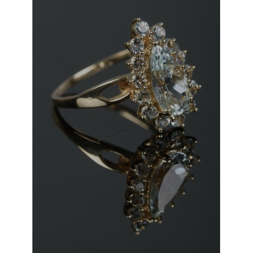 340 - A 10ct gold cluster ring set with pale blue/green stones, with one large pear cut stone under a bord... 