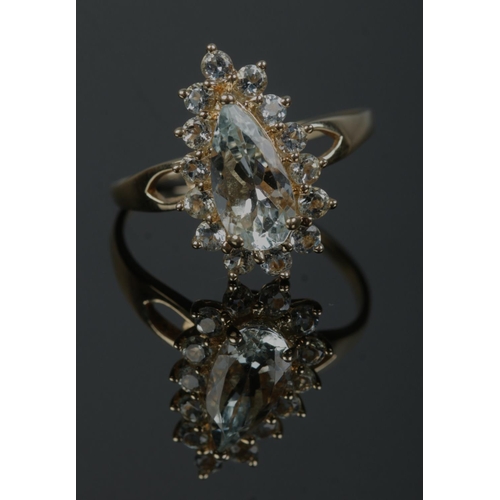 340 - A 10ct gold cluster ring set with pale blue/green stones, with one large pear cut stone under a bord... 