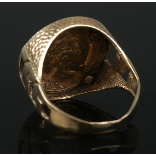 343 - A 9ct Gold mounted half sovereign ring, with pierced shoulders. Size W. Total weight: 9.3g. Stamped ... 