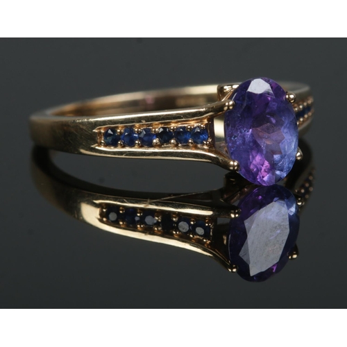 357 - A 9ct Gold Tanzanite solitaire ring, set with smaller stones to the shoulders and a small diamond to... 