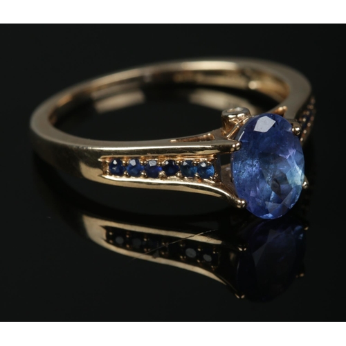 357 - A 9ct Gold Tanzanite solitaire ring, set with smaller stones to the shoulders and a small diamond to... 