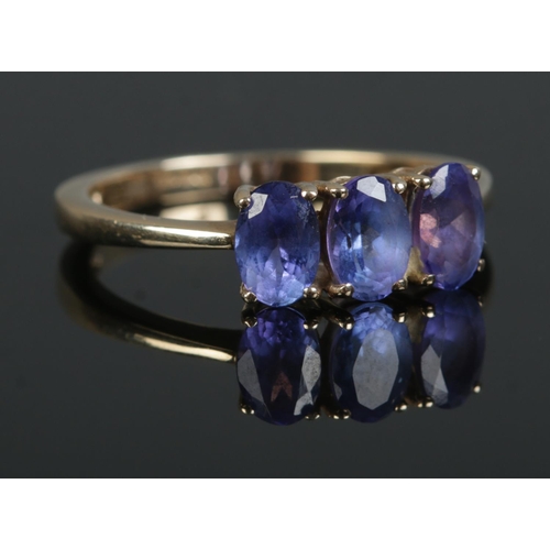 363 - A 9ct Gold three stone Iolite ring. Stamped 375 to the inside of the band.  Size O. Total weight: 2.... 