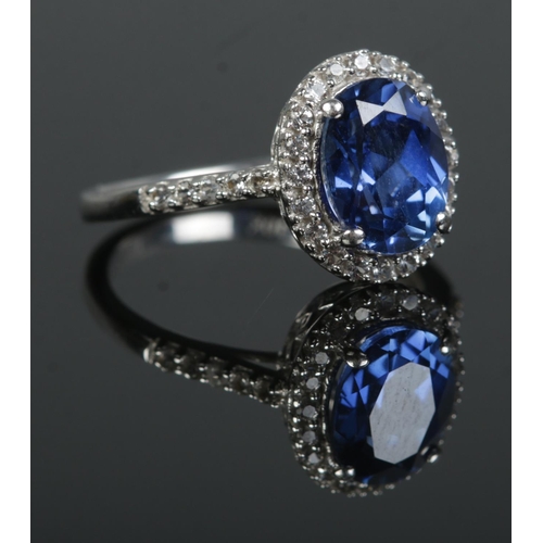 364 - A 10ct White Gold ring, set with large faceted blue stone surrounded by pasted stones and having pas... 