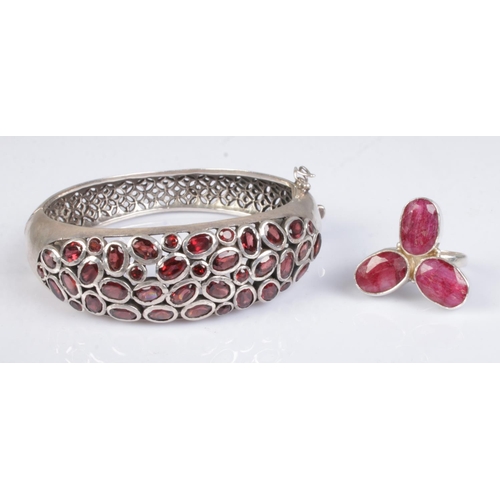 369 - Two pieces of silver jewellery; consisting of a hinged bangle with pierced decoration, half set with... 