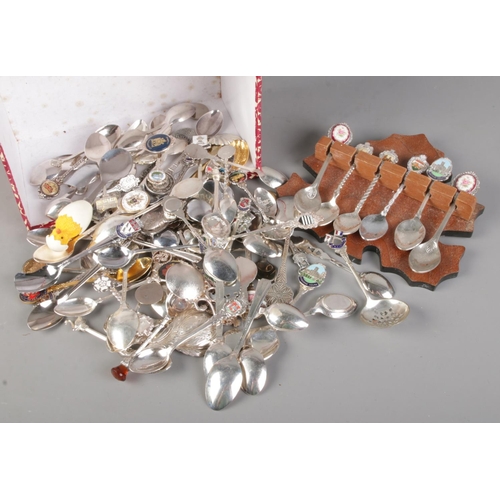 62 - A box of collectors/souvenir spoons. Includes small oak spoon rack.