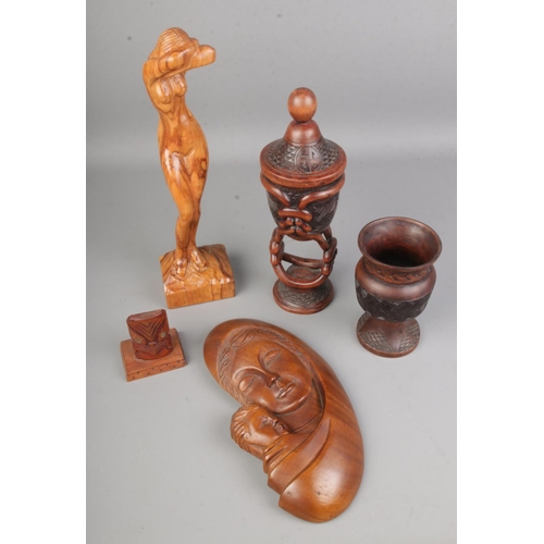 71 - A collection of carved woodenwares including a lidded tobacco jar with intricately carved stem, a mo... 