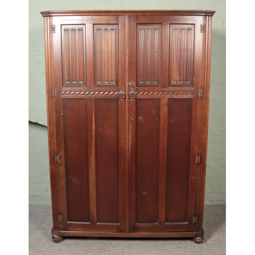 451 - A Butilux oak double wardrobe along with matching chest of six drawers. Both having linen fold decor... 