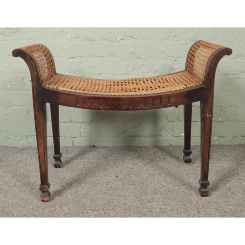 472 - A late Nineteenth/early Twentieth century mahogany window seat/stool, with bergère base. Width: 77cm... 