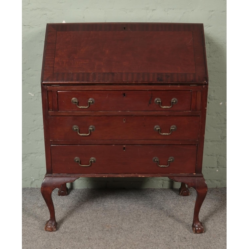 478 - A mahogany three drawer bureau, with fold down top and fitted interior. Raised on ball and claw supp... 