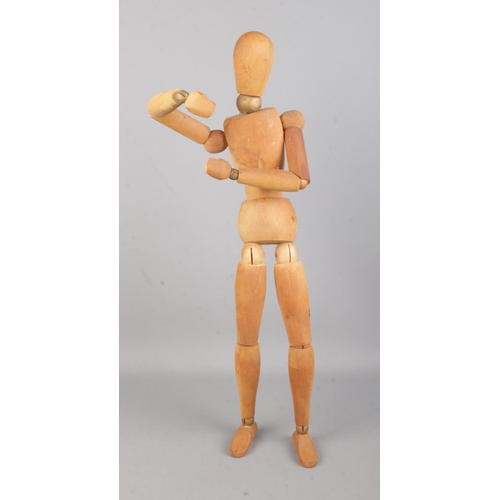 92 - A large jointed and articulated wooden mannequin; 52cm tall.