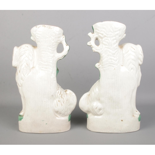 11 - A large pair of Staffordshire dog spill vases. Height 33cm.