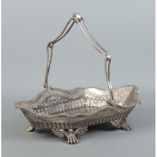 120 - An Edwardian silver basket with swing handle, pierced decoration and raised on four paw feet. 628g.